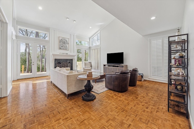 living area featuring baseboards, a fireplace, high vaulted ceiling, and recessed lighting