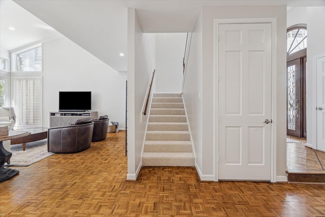 staircase with high vaulted ceiling, recessed lighting, and baseboards