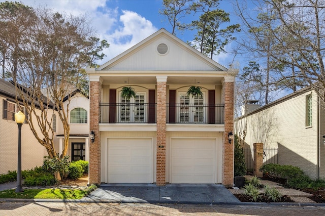 view of front of house featuring driveway, a balcony, an attached garage, and brick siding