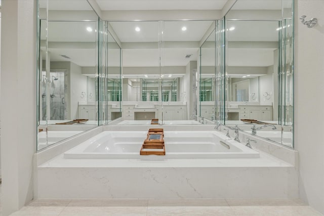 bathroom with a garden tub and vanity