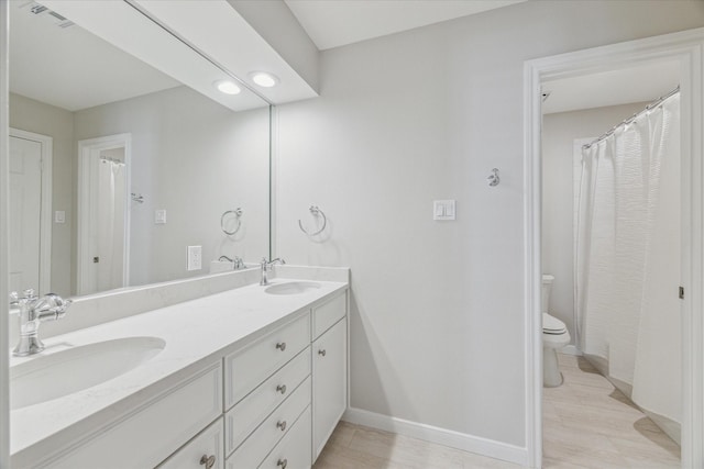 full bathroom featuring visible vents, a sink, baseboards, and double vanity