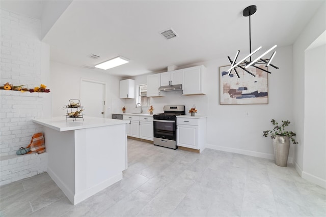 kitchen with light countertops, stainless steel gas stove, under cabinet range hood, and white cabinetry