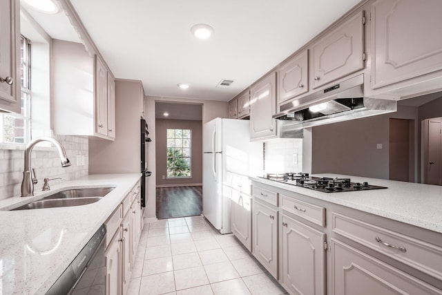 20650 S Hillcrest Dr, Porter, TX 77365 - kitchen with a sink, under cabinet range hood, black appliances, light tile patterned floors, and backsplash