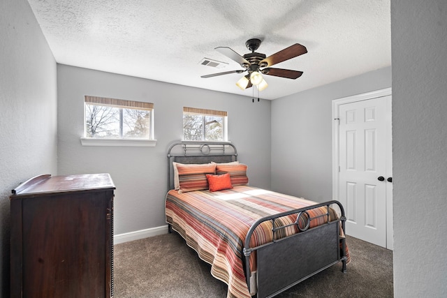 carpeted bedroom with ceiling fan, visible vents, a textured ceiling, and a textured wall