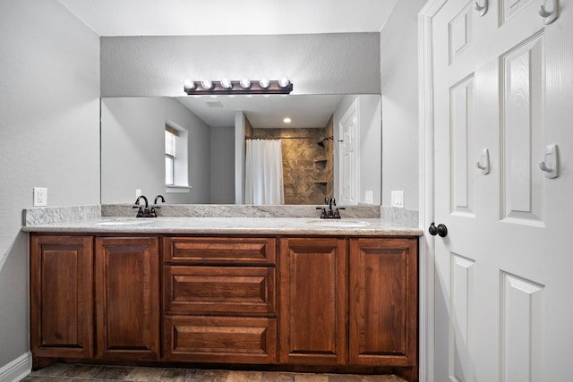 full bath featuring double vanity, a shower with shower curtain, and a sink