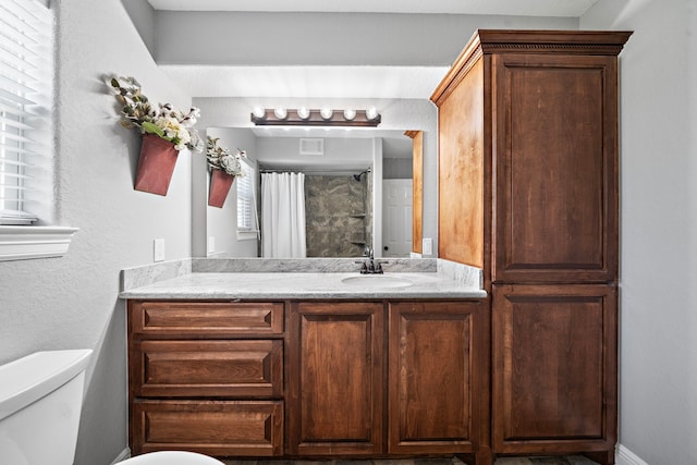 bathroom featuring toilet, vanity, and a shower with shower curtain