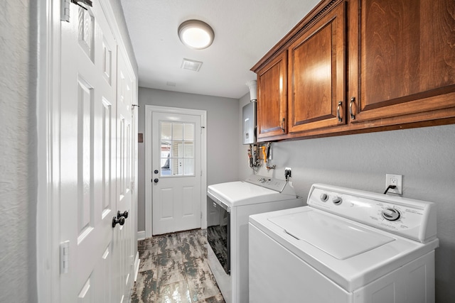 clothes washing area with cabinet space and separate washer and dryer