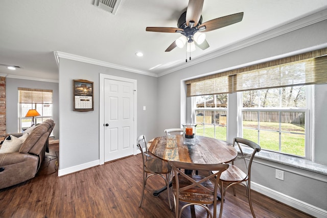 dining space featuring baseboards, visible vents, dark wood finished floors, and crown molding