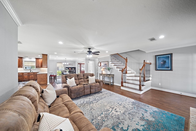 living area with dark wood-style floors, stairs, visible vents, and crown molding