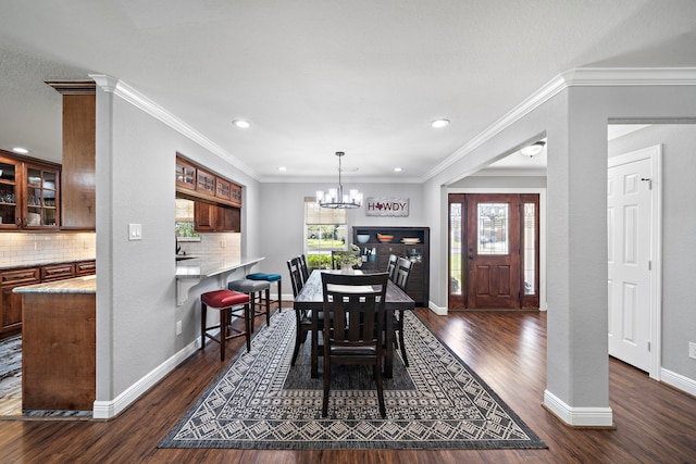 dining area featuring an inviting chandelier, baseboards, dark wood-type flooring, and a wealth of natural light