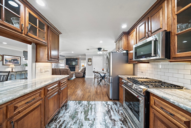 kitchen featuring light stone countertops, dark wood-style floors, ceiling fan, and appliances with stainless steel finishes