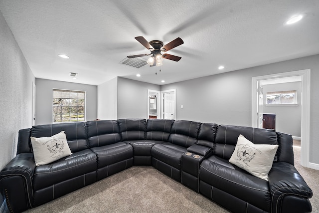 living area featuring carpet floors, visible vents, a textured ceiling, and recessed lighting