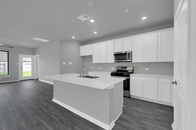 715 Whispering Winds Dr, Beasley, TX 77417 - kitchen with stainless steel appliances, a sink, dark wood-style flooring, a kitchen island with sink, and recessed lighting