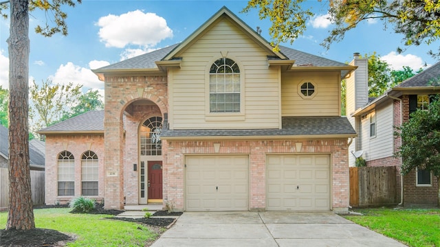 traditional-style home with concrete driveway, brick siding, roof with shingles, and fence