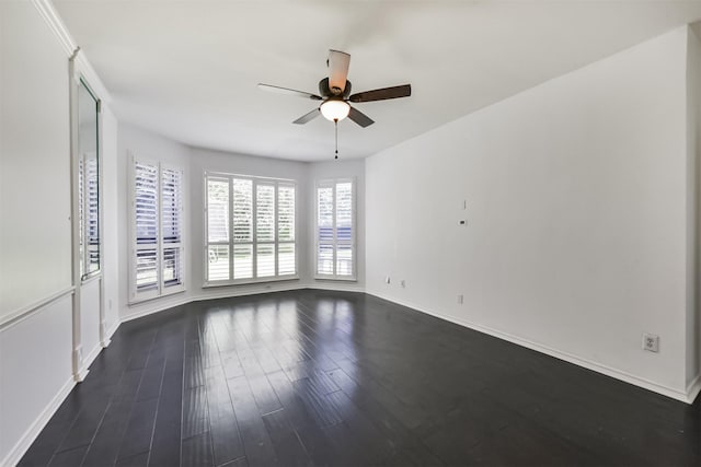 unfurnished room featuring baseboards, dark wood finished floors, and a ceiling fan