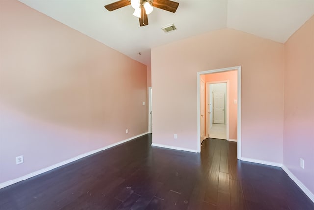 spare room with baseboards, visible vents, a ceiling fan, dark wood-style floors, and vaulted ceiling