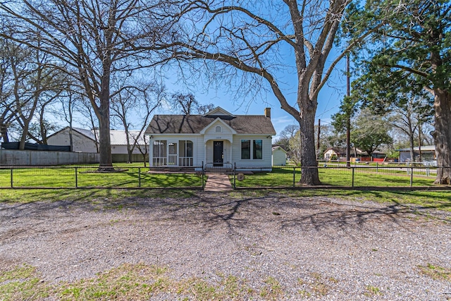 view of front of property with a fenced front yard, a chimney, a gate, and a front yard