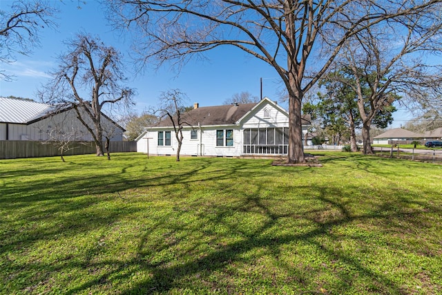 back of house featuring a chimney, a lawn, a sunroom, crawl space, and a fenced backyard