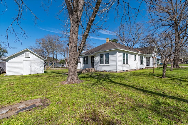 exterior space with a storage shed, an outdoor structure, a yard, crawl space, and a chimney