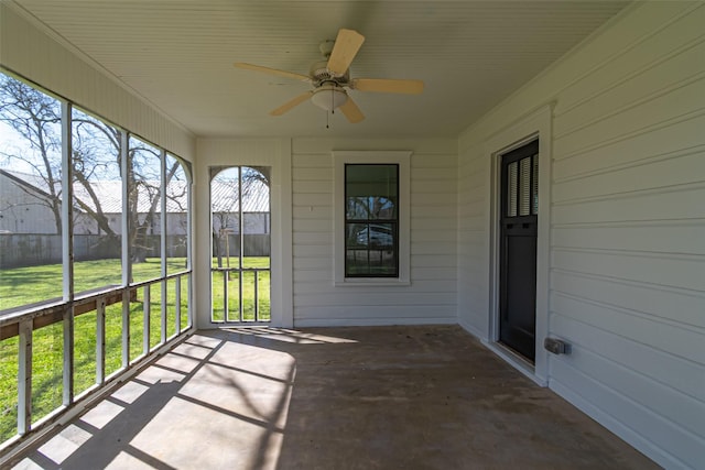 unfurnished sunroom featuring ceiling fan