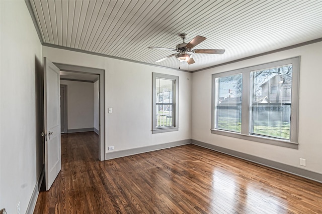 spare room with a ceiling fan, crown molding, baseboards, and wood finished floors