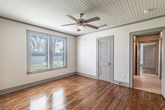 unfurnished bedroom with crown molding, baseboards, and wood finished floors