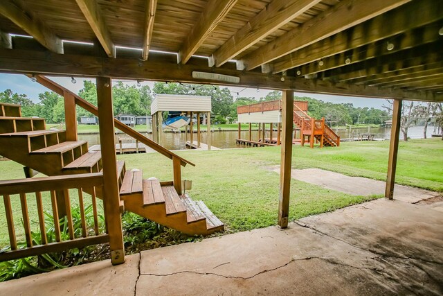 view of patio / terrace with a dock, a water view, and stairway