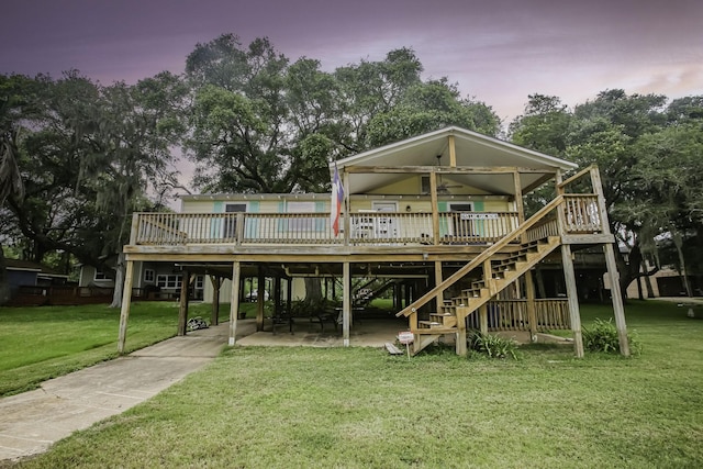 back of property with stairs, a patio, a lawn, and a wooden deck