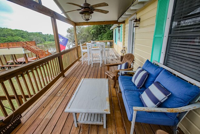 deck featuring outdoor dining area, a ceiling fan, and an outdoor living space