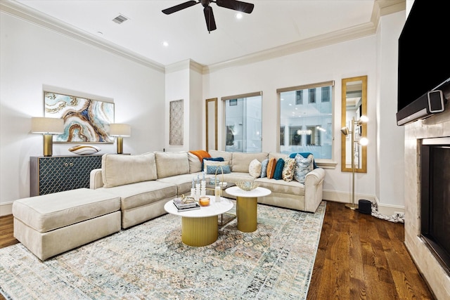 living area with dark wood finished floors, a fireplace, visible vents, ornamental molding, and baseboards