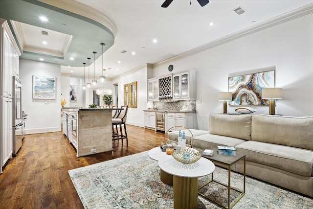 living area featuring wine cooler, recessed lighting, wet bar, dark wood-style floors, and crown molding