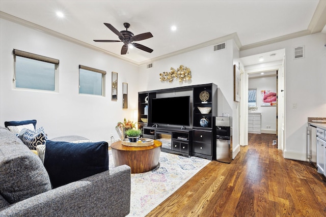 living room with visible vents, crown molding, and wood finished floors