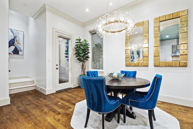 dining area with ornamental molding, a chandelier, baseboards, and wood finished floors