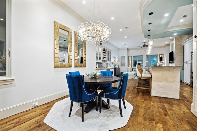 dining area with baseboards, ornamental molding, wood finished floors, and recessed lighting