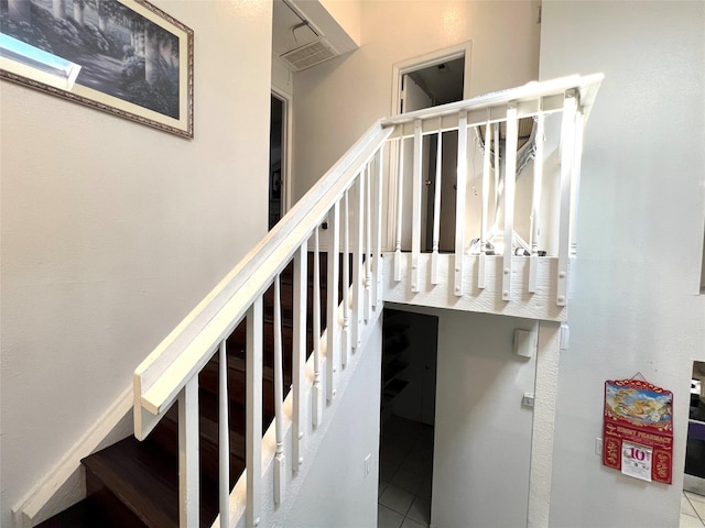 staircase with a skylight and tile patterned floors