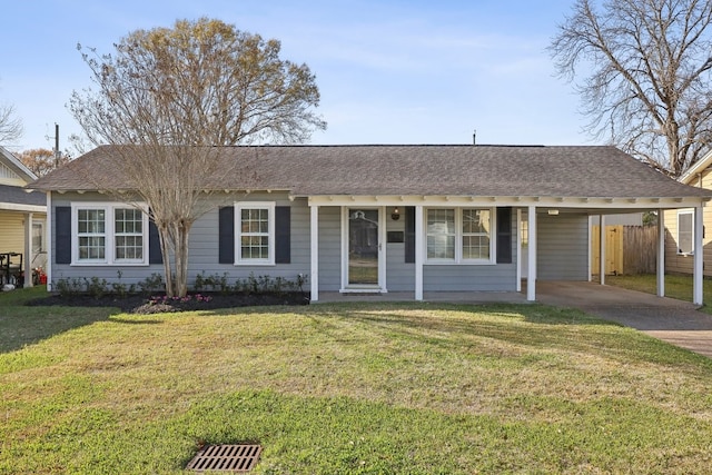 ranch-style house featuring a shingled roof, concrete driveway, an attached carport, fence, and a front yard