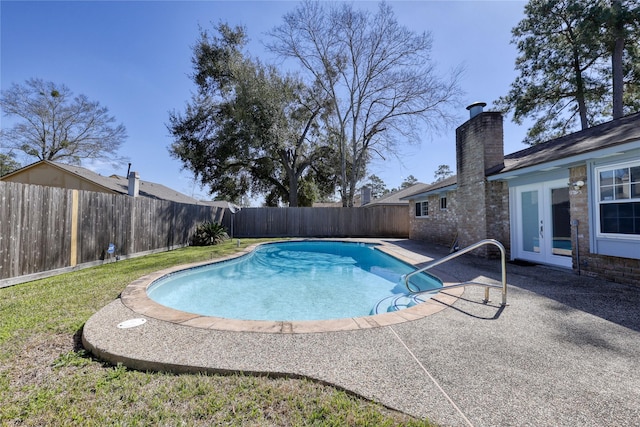 view of swimming pool with a fenced backyard, a fenced in pool, a patio, and french doors