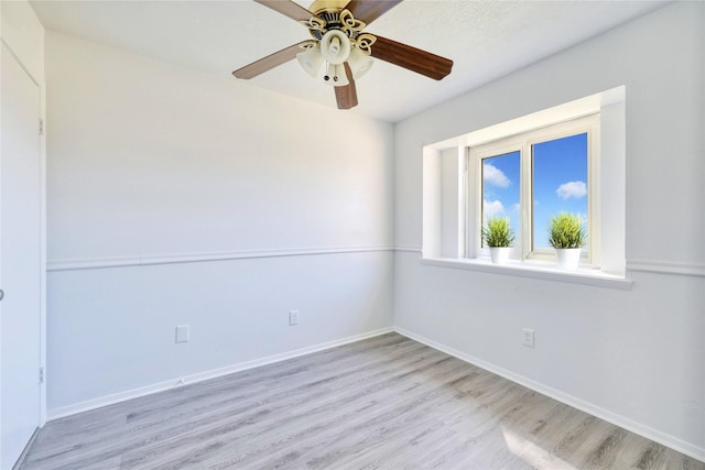 empty room with ceiling fan, baseboards, and wood finished floors