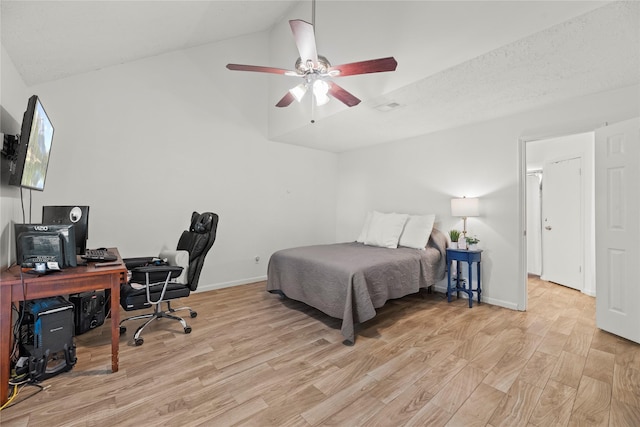 bedroom featuring visible vents, a ceiling fan, vaulted ceiling, wood finished floors, and baseboards