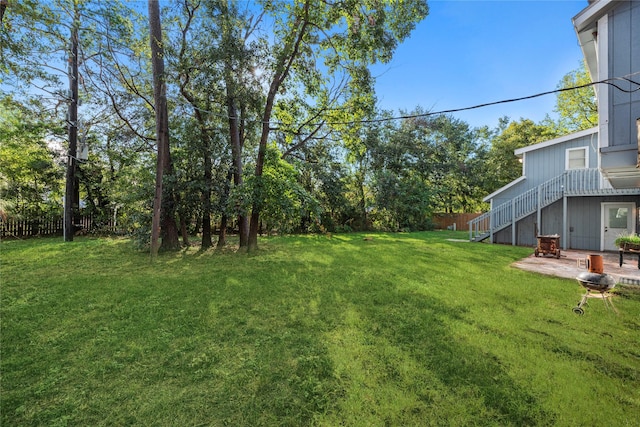 view of yard with a patio, stairway, and fence