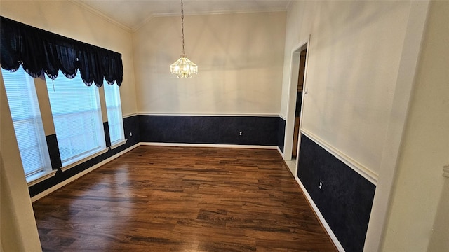 unfurnished room featuring crown molding, a notable chandelier, wainscoting, vaulted ceiling, and wood finished floors