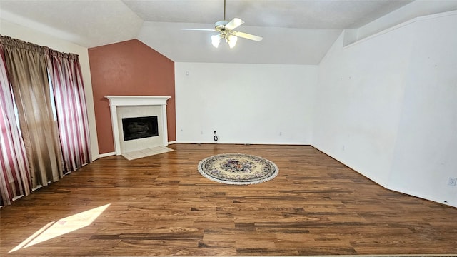 unfurnished living room featuring lofted ceiling, a fireplace with flush hearth, ceiling fan, and wood finished floors