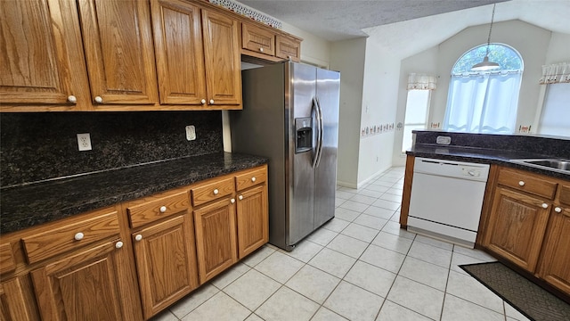 kitchen with brown cabinetry, light tile patterned floors, stainless steel refrigerator with ice dispenser, and dishwasher