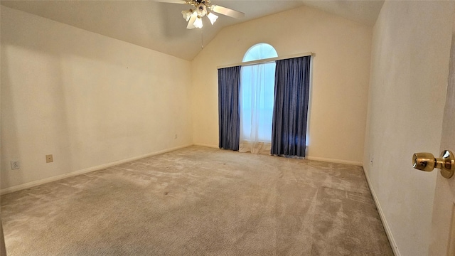 carpeted spare room with lofted ceiling, ceiling fan, and baseboards