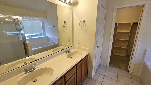 bathroom with a bath, tile patterned flooring, double vanity, and a sink