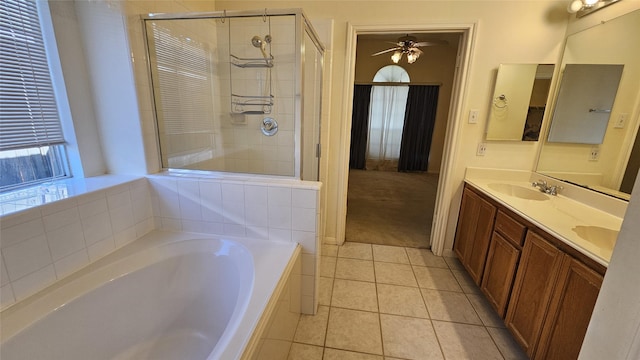 bathroom with a garden tub, double vanity, a stall shower, a sink, and tile patterned flooring