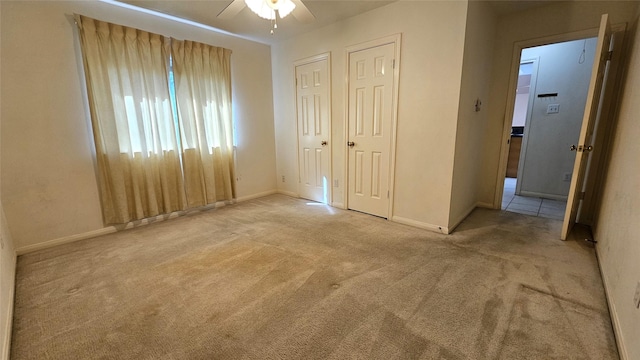 unfurnished bedroom with carpet flooring, a ceiling fan, and baseboards