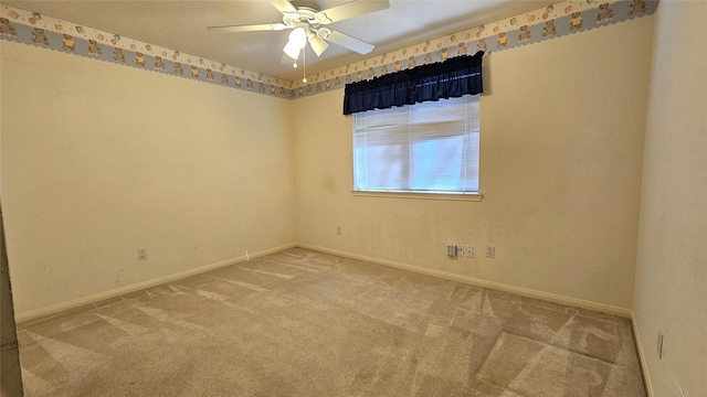 carpeted empty room featuring ceiling fan and baseboards