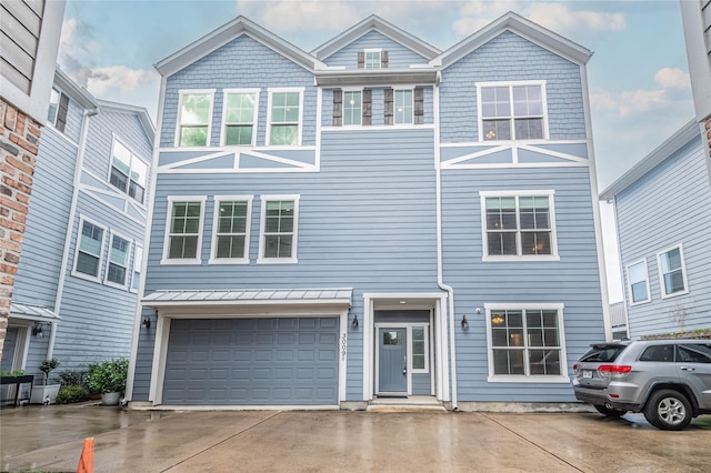 view of property featuring driveway, a standing seam roof, and an attached garage