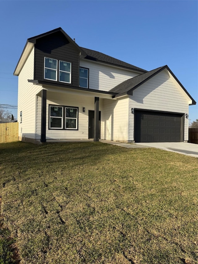 view of front of house featuring an attached garage, driveway, fence, and a front lawn